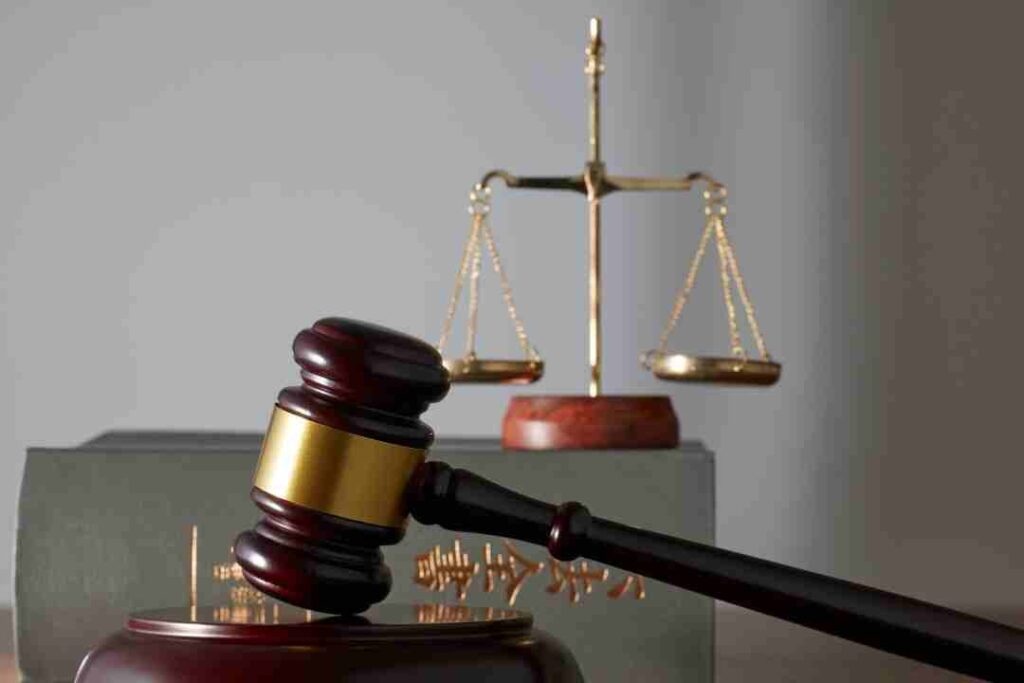 Gavel and scales of justice over a law book.